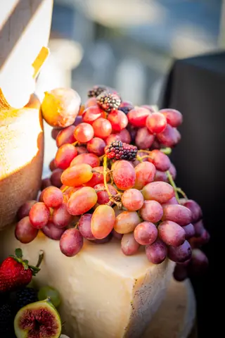 Grapes and berries piled on a cheese wheel at the event's grazing table