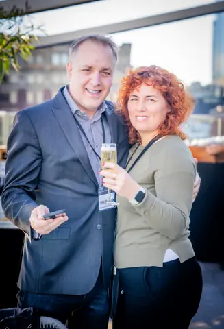 Two guests posing together on the rooftop at golden hour