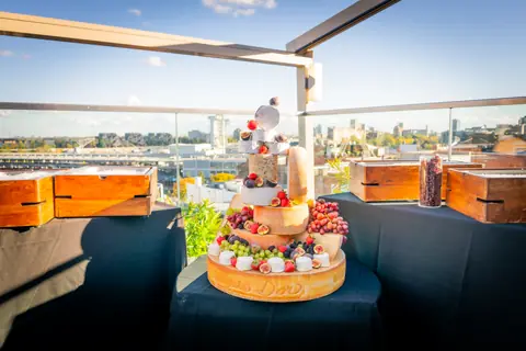 Grazing table with a cheese tower on the rooftop terrace overlooking the Old Port of Montreal