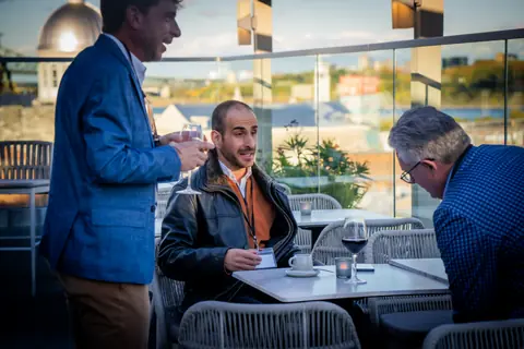 Attendees talking around a terrace table at the ElevateOS Montreal event