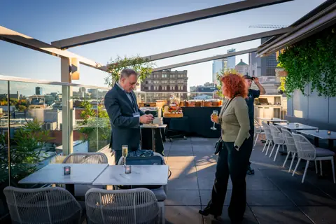 Early guests arriving on the rooftop terrace
