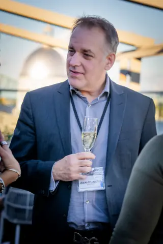 Attendee with a glass of champagne on the rooftop