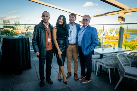 Four guests posing together on the terrace at golden hour