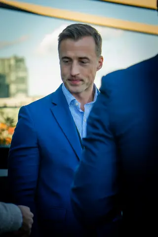 Guest in a blue blazer chatting on the terrace