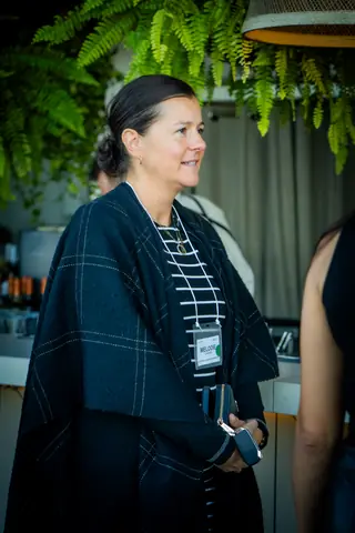 Attendee standing by the bar under hanging ferns