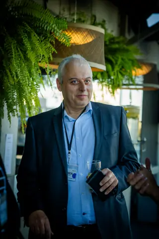 Attendee with an event lanyard speaking by the bar