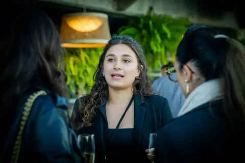 Attendee speaking with two other guests by the bar