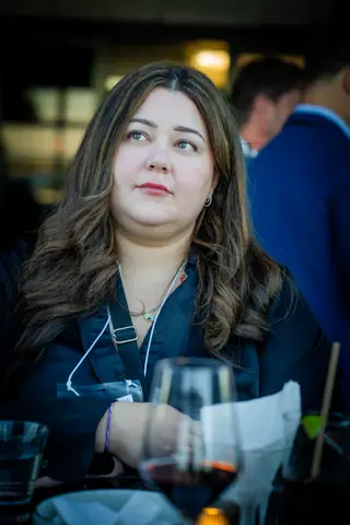 Guest holding a glass of red wine on the terrace