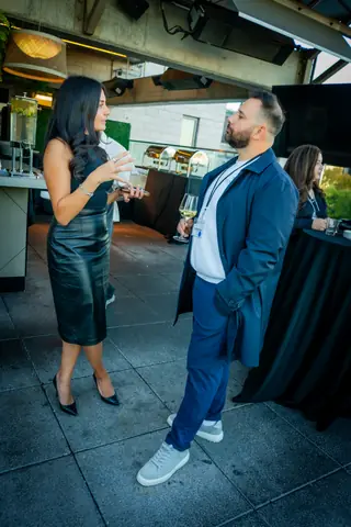 Two guests talking on the rooftop near the bar