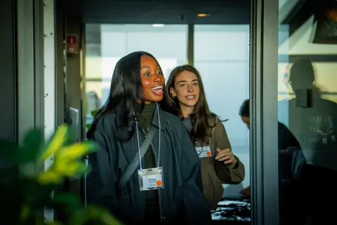 Two attendees arriving through the doors to the rooftop terrace