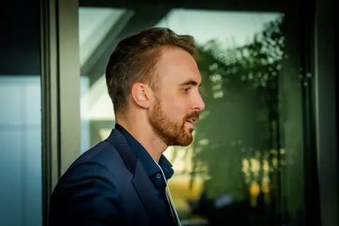 Attendee in profile listening during a conversation by the window