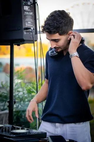 DJ adjusting his headphones beside the rooftop speakers