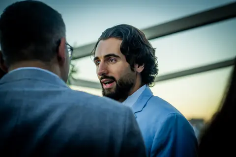Two attendees in conversation at dusk