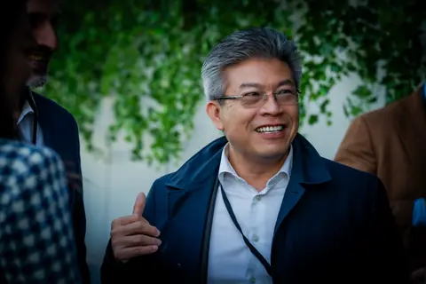 Attendee in a navy jacket laughing and gesturing during a conversation
