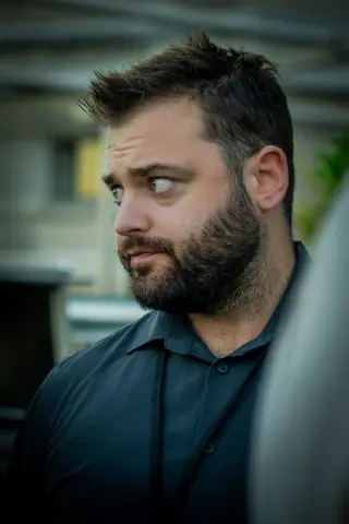 Attendee glancing across the terrace during a conversation