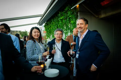 Attendees with wine talking around a terrace table as the evening goes on