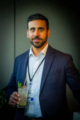 Attendee in a navy blazer holding a cocktail