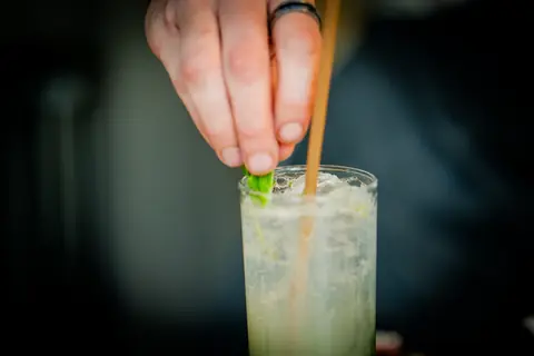 Bartender garnishing a cocktail with fresh mint