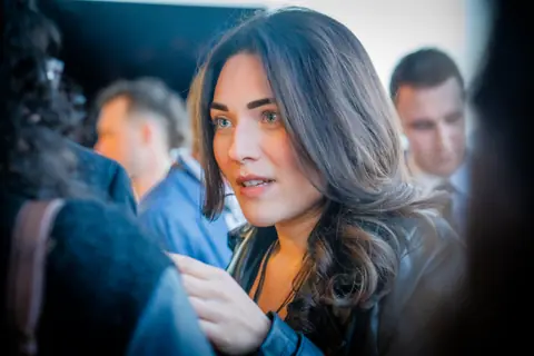 Attendee listening closely during a conversation in the crowd