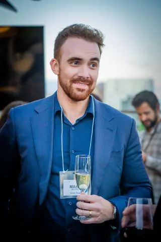 Attendee in a blue suit with a glass of champagne