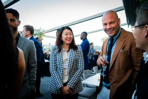 Attendees laughing together on the busy rooftop terrace
