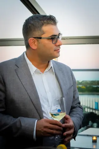 Attendee in a gray blazer holding a drink