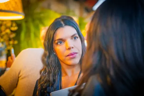Attendee listening during a conversation under the warm evening lights