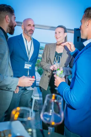 Attendees chatting around a high table at blue hour