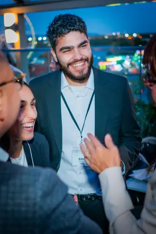Attendee laughing during a conversation as night falls