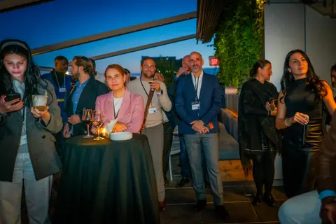 Attendees standing around high tables during the panel discussion