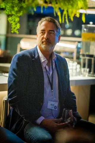 Panelist in a navy blazer listening to a question