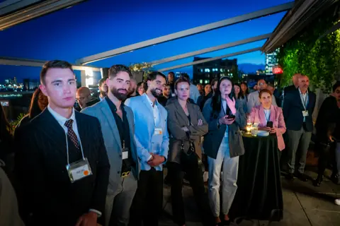 Attendees listening to the panel with the Montreal skyline lit up behind them