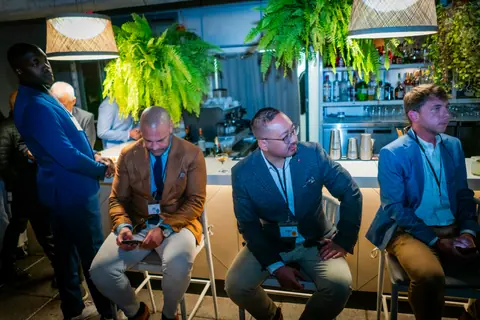Panelists on stools in front of the rooftop bar during the discussion