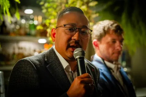 Panelist in glasses speaking during the discussion