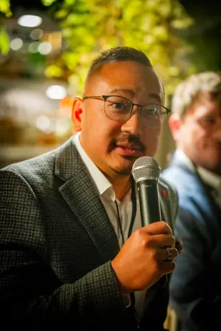 Panelist in glasses holding the microphone