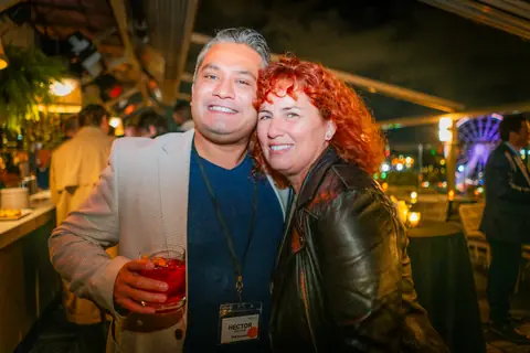Two attendees posing together with drinks after the panel