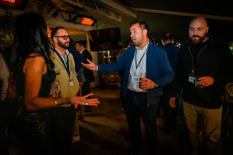 Attendees greeting each other on the terrace at night