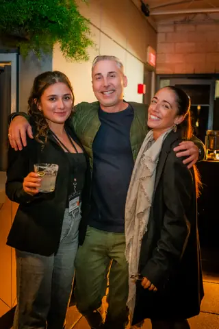 Three attendees posing together near the end of the evening