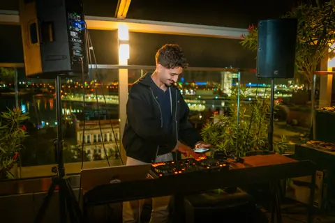DJ playing a late set at the rooftop booth overlooking the Old Port