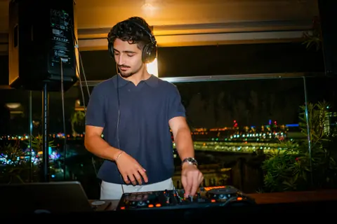 DJ at the decks above the lights of Old Montreal