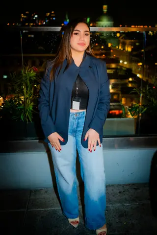 Attendee in a navy jacket posing with Old Montreal lit up behind her