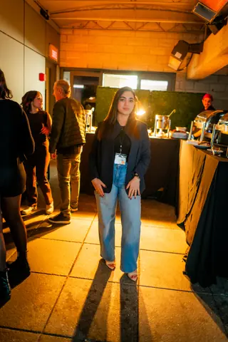Attendee standing by the welcome table late in the evening