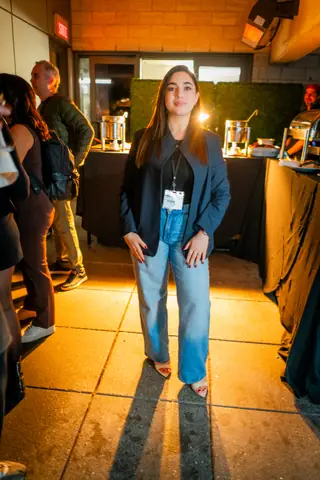 Attendee with an event badge posing near the entrance to the rooftop