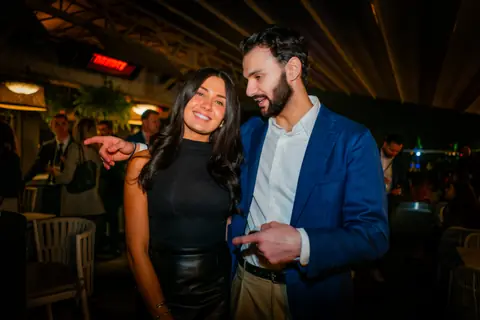 Two attendees laughing and pointing at the camera