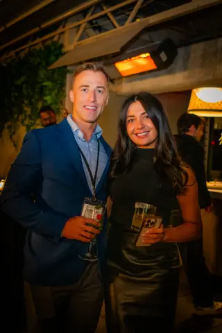 Two attendees smiling together late in the evening
